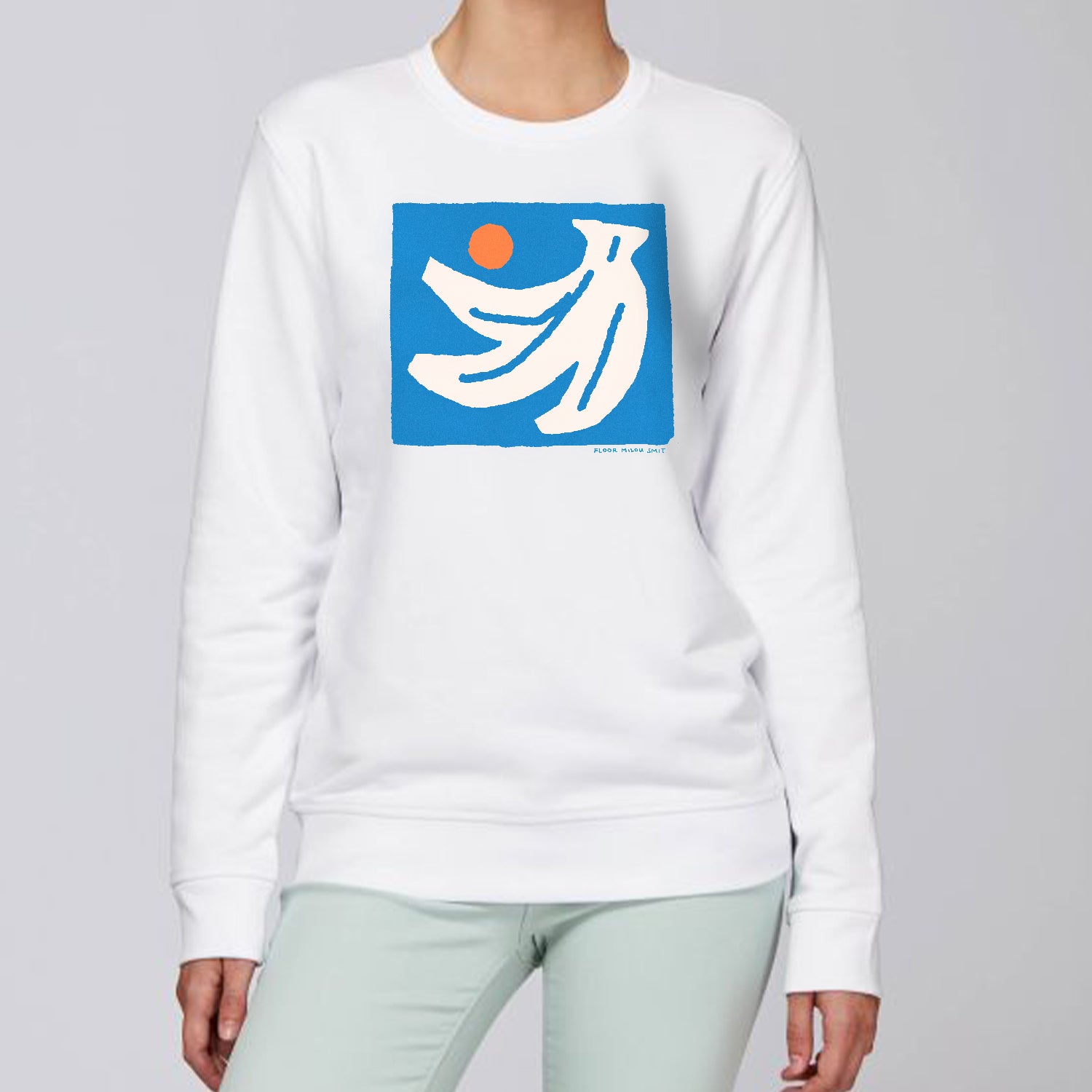 Photo of a model wearing a white sweater. The print on the sweater is an off-white hand of bananas with an orange circle next to them on a blue square background.